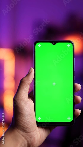 Hand Holding a Smartphone with Green Screen Display and Tracking Markers for Digital Content Editing and Compositing
