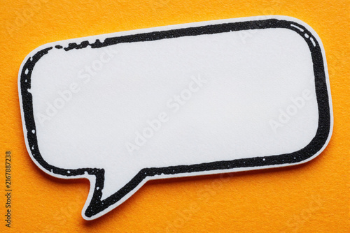 White blank speech bubble icon with black outline on bright orange background. Empty comic chat bubble for text message. Simple graphic element for communication, marketing, business presentation.