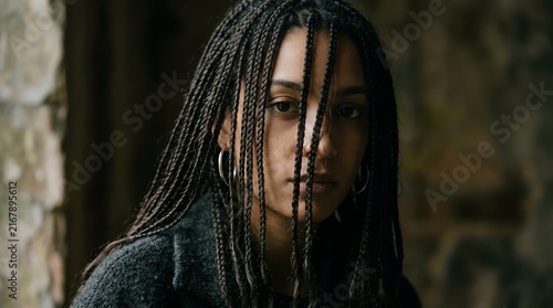 Portrait of a Young Woman with Braided Hair in Natural Setting.