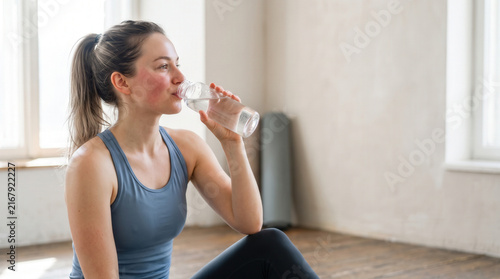 Athletic Woman Drinking Water After Indoor Workout