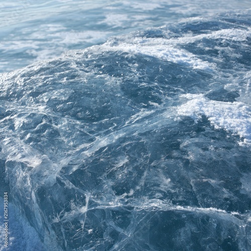 Close up of textured blue ice surface with snow details
