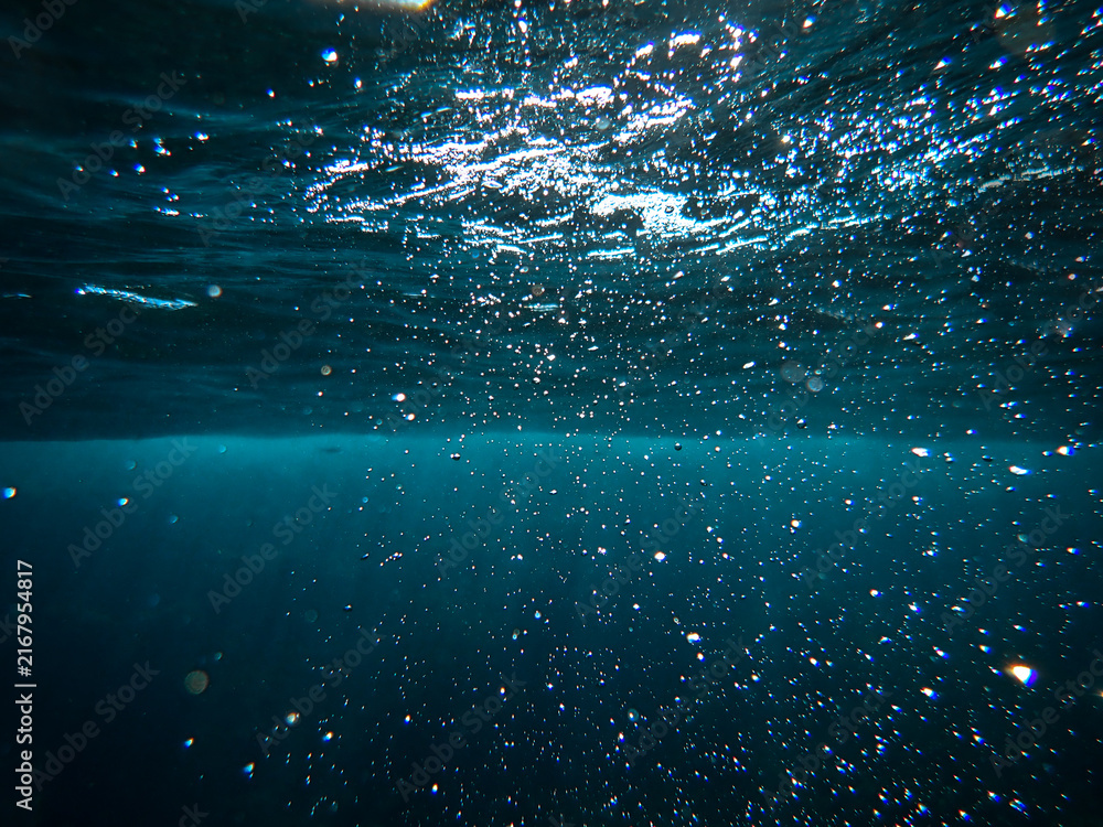 Fototapeta premium sea, underwater, sunlight, water, background, ocean, under, wave, blue, deep, undersea, light, rays, diving, marine, sun, abstract, surface, clean, texture, sunbeam, dark, clear, nature, aquatic sea.