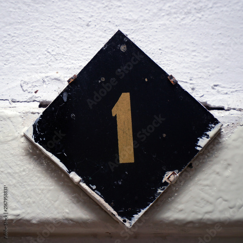 Number one sign on a wall Or the door