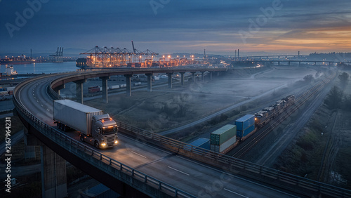Intermodal Freight Transport with Semi Truck Highway and Cargo Train at Sunrise