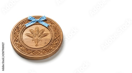 Traditional carved wooden plate with wheat motif and Bavarian ribbon for Oktoberfest copy space