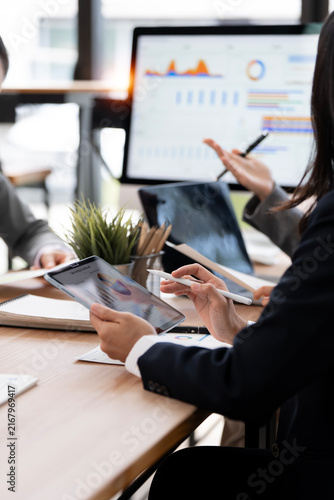 Close Up Business Professional Holding Digital Tablet and Stylus Pen with Computer Monitor Background