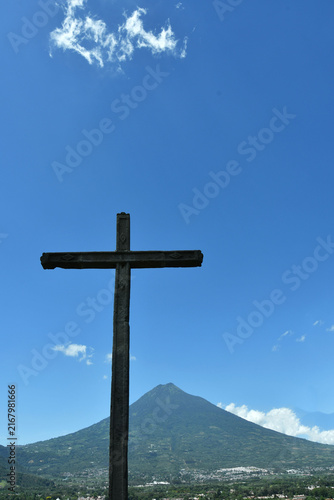 Konstfotografi Cruz de piedra con vista hacia el cielo azul y volcán de agua en Antigua Guatemala