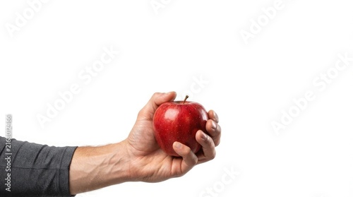 A close up view of a male hand holding a fresh ripe red apple isolated on a white background representing healthy nutrition and organic fruit food