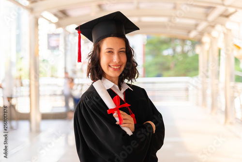 Happy young woman with diploma on graduation day