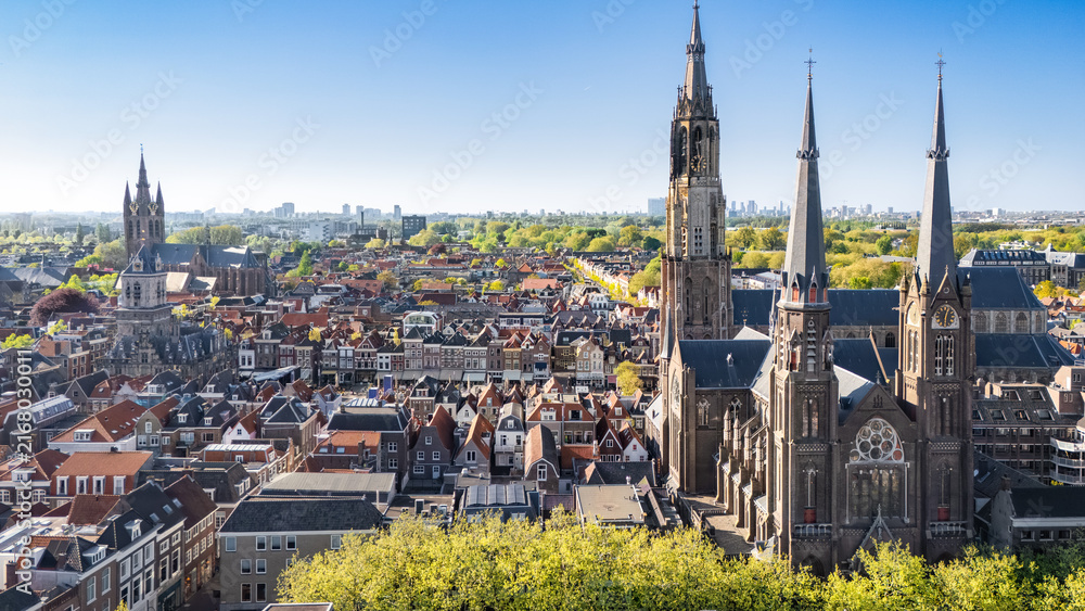 Obraz premium Aerial drone view of Delft with historic cathedrals, panoramic cityscape of old town Delft with traditional Dutch architecture, market square and city center, the Netherlands