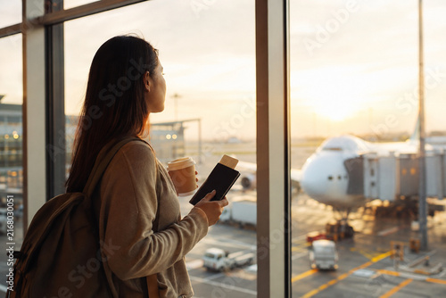 Traveler Watching Sunrise Through Airport Window
