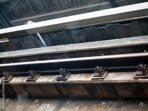 Bild auf Leinwand Close-up view of train tracks on a bridge, showing the concrete structure and me