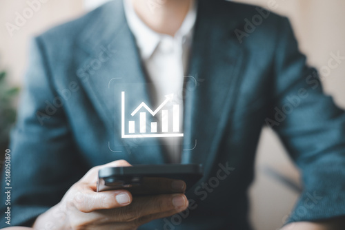 Business professional using smartphone with financial growth chart for investment analysis, business performance, revenue growth, market analytics, mobile finance, and digital strategy.