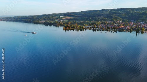 Aerial View of Passenger Boat Cruising on Serene Lake and Coastal Town