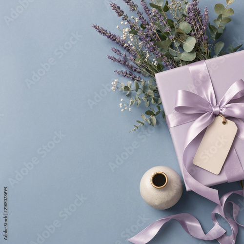 Gift box with lavender flowers and ribbon on blue background