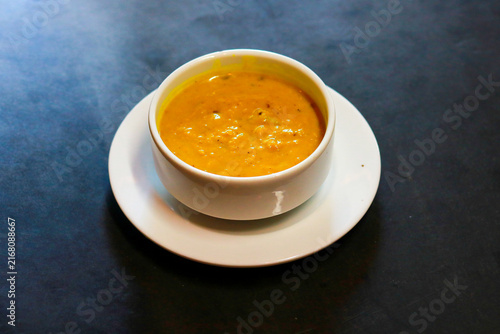 Obraz na plátne Creamy Yellow Lentil Soup or Dal Curry Served in White Bowl on Saucer