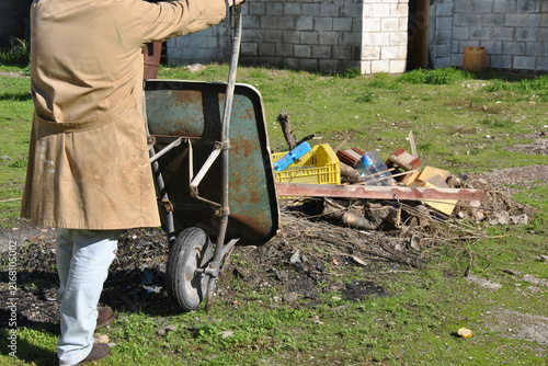 Quadro su tela Person pushing wheelbarrow cleaning construction waste