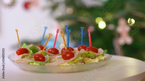 Festive Holiday Appetizers Rotating on a Plate with Christmas Tree Background