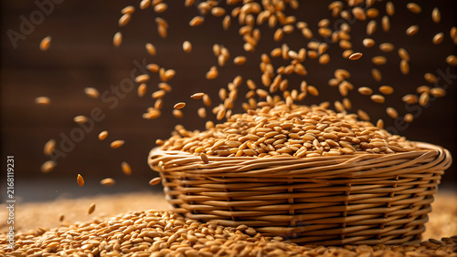 Golden wheat grains spilling from rustic woven basket in warm harvest sunlight
