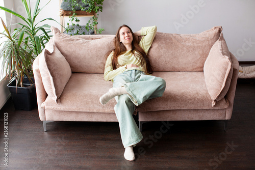 Foto Woman relaxing on beige sofa at home living room