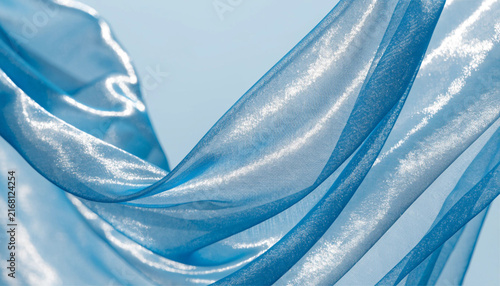 Light blue satin fabric waving in the wind abstract background