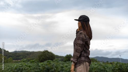 Cuadro en lienzo A woman stands in a field, gazing at the cloudy sky