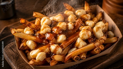 Traditional Canadian poutine with cheese curds and gravy, rustic french fries in cardboard tray, comfort food for restaurant menus