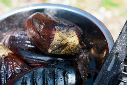 Close-up of whole roasted eggplants in a metal bowl