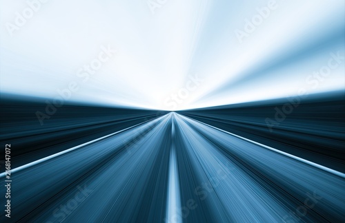 Blurry highway vanishing into a bright, distant horizon