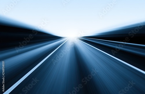 Endless highway vanishing into a bright, blurred horizon