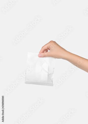 Hand Holding Crumpled White Pouch Packaging Mockup on Neutral Background