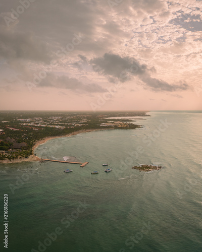 Drone view of sandy beach with wooden pier leading over the ocean at sunset.Scenic Caribbean coastline view in Playa del Carmen,Summer vacation and travel destination,Cancun,Mexico