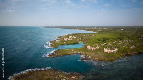 Aerial view of beautiful beach, blue Caribbean sea, luxury resort,wonderful cliff and palm trees surrounded. Sunny day, blue sky. Playa del Carmen, Riviera Maya, Mexico.