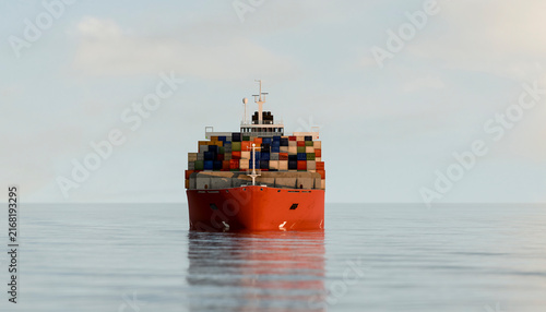 A red container ship loaded with cargo containers sails on calm ocean