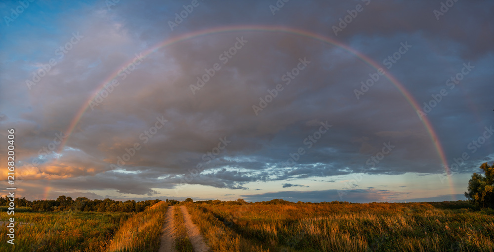 Naklejka premium A magnificent and beautiful rainbow after an evening rainfall
