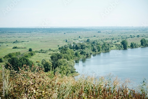 Bild auf Leinwand Panoramic summer landscape of the Kama River, with meadows and green trees on the bank