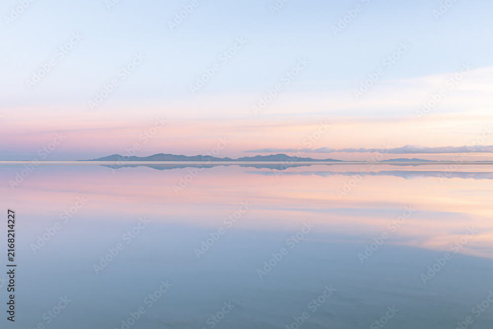 Obraz premium Soft Pastel Reflection of Distant Mountains and Sky on Calm Water