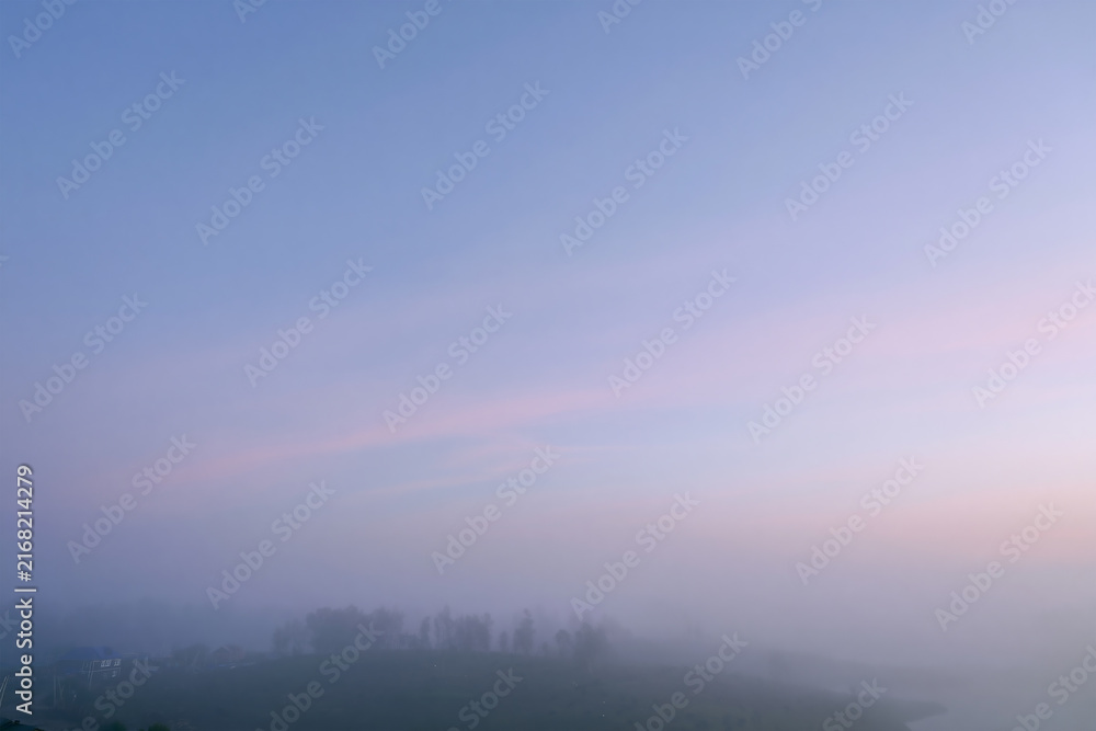 Obraz premium Soft Pastel Sunrise Sky Over Foggy Countryside Village