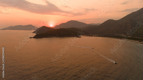 Photography Sun Setting Behind Coastal Headland with Two Boats on Golden Sea