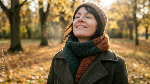 Woman breathing fresh air outdoors in autumn park for health and wellness recovery concept.