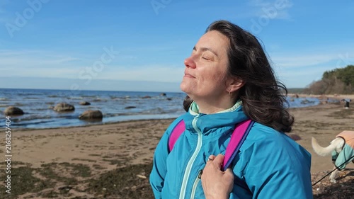 Woman enjoys the beach and sun on a clear day by the water