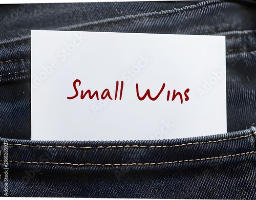 Jeans pocket with note written SMALL WINS, tiny everyday achievements that build inner joy and push you toward big goals.Turns scary goals into simple steps.