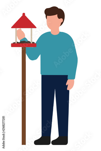 Hand-drawn vector illustration of a smiling man in a teal sweater standing beside a wooden post topped with a charming red bird feeder filled with seeds, perfect for nature and hobby designs