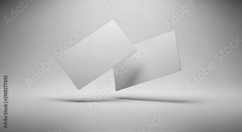 Two blank white business cards floating in a studio setting.