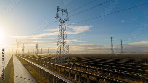 Фотография Solar Power Farm with High Voltage Transmission Towers