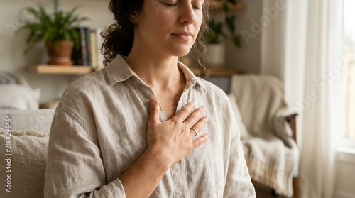 Woman practicing mindful breathing with hand on heart for stress relief and mental wellness.
