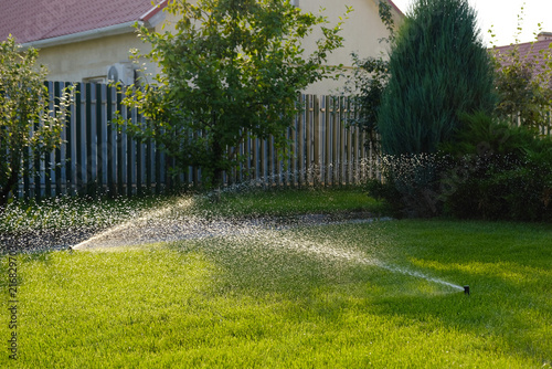 Automatic garden irrigation system watering lawn. Savings of water from sprinkler irrigation system with adjustable head. Automatic equipment for irrigation and maintenance of lawns, gardening.