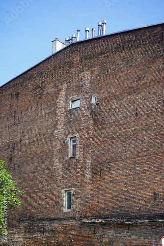 Fotografie Detailed view of a tall historic weathered red brick firewall of a tenement building in Gdansk, Poland, showing vintage masonry patterns and small windows