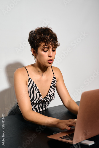 Businesswoman working at Office. DIrect flash shot. She types intently on her laptop