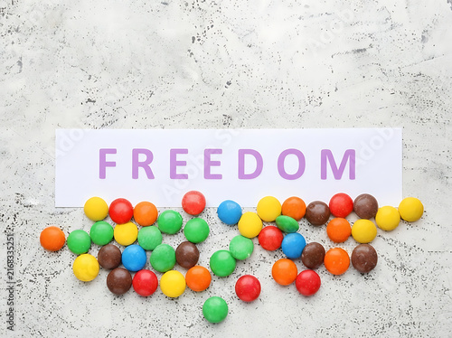 Colorful chocolate candies scattered around a card with the word Freedom written on it
